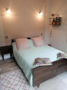 - une chambre dotée d'un grand lit avec des draps blancs et des oreillers roses dans l'établissement L ARDECHE VERTE, à Saint-Martin-de-Valamas