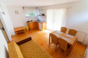a living room with a table and chairs and a kitchen at House Jakob Camping Ananas Cisnadioara in Cisnădioara