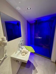 uma casa de banho com um lavatório e um chuveiro com luzes azuis em Rieder Stubn em Ried im Oberinntal