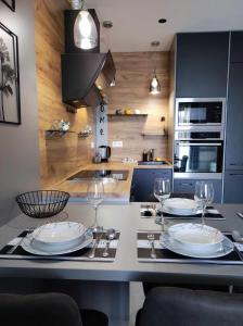 uma cozinha com uma mesa com pratos e copos de vinho em Apartman Aranyhal City em Sárvár