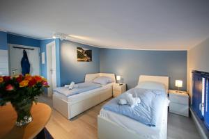 a bedroom with two beds and a table with flowers at Kuhnle-Tours Niderviller Apartments in Niderviller