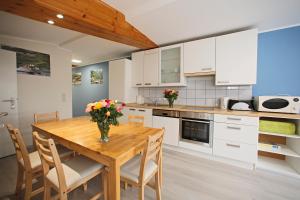 uma cozinha com uma mesa de madeira com flores em Kuhnle-Tours Niderviller Apartments em Niderviller