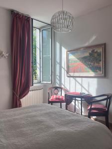 a bedroom with a bed and two chairs and a window at La Dolce Vita in Levanto