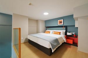 a bedroom with a large bed with blue walls at Livetour Hotel Panyu Nancun Wanbo Metro Guangzhou in Guangzhou