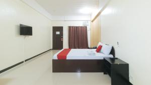 um quarto com uma cama e uma televisão em RedDoorz near SM City Muntinlupa em Manila