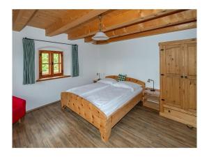 um quarto com uma cama de madeira e uma janela em Infanglalm "Traunsee" em Neukirchen