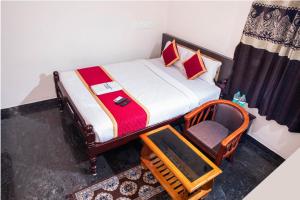 - une petite chambre avec un lit et une chaise dans l'établissement MUTHU RESIDENCY, à Thanjavur