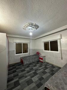 Habitación con sofá y 2 ventanas. en شقة مفروشة للايجار, en Irbid