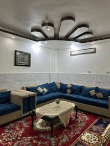 a living room with a blue couch and a table at شقة مفروشة للايجار in Irbid