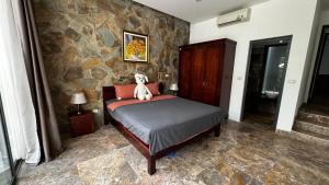 Un dormitorio con una cama con un osito de peluche. en Flamingo Đại Lải Resort - Bách Thanh C16, en Phúc Yên