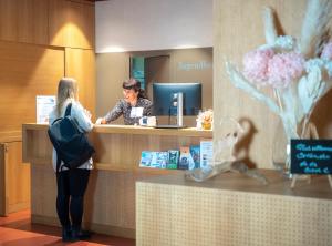 a woman standing at a counter in a hotel at Zug Youth Hostel in Zug