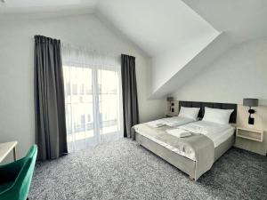 a bedroom with a bed and a large window at SILVER BALTIC in Kołobrzeg