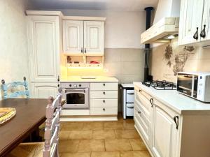 uma cozinha com armários brancos e uma bancada em Il Nido di Torri em Sovicille