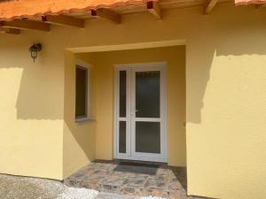 una casa con una puerta blanca y una ventana en House sunlight, en Vranino 21 fotos más