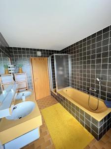 un bagno con 2 lavandini e una vasca di Terrasse mit Ausblick a Biedenkopf