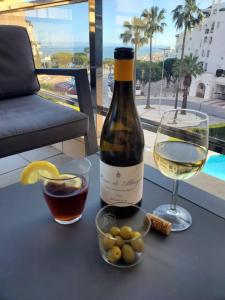 una botella de vino blanco y una copa de vino en Apartamento Moderno, Bonito y Acogedor, en Torremolinos