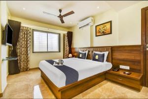 a bedroom with a large bed and a television at Hotel Hangout in Pune