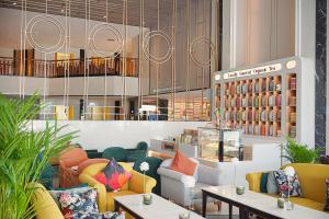 Siam Mandarina Hotel - Free BKK Airport Shuttle في لاكريبنغ لاد: وجود مخزن مع الأرائك والطاولات في الغرفة