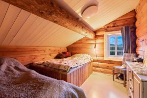 um quarto com uma cama num chalé de madeira em Luxurious and modern log cabin close to nature em Lislevatn