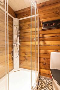 a shower in a bathroom with wooden walls at Luxurious and modern log cabin close to nature in Lislevatn
