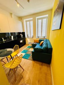 uma sala de estar com um sofá, uma mesa e cadeiras em Apartment Targowa L8 em Lublin