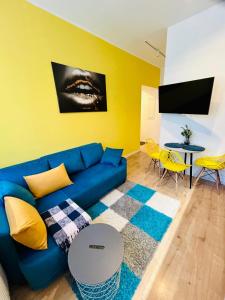 a living room with a blue couch and a yellow wall at Apartment Targowa L8 in Lublin