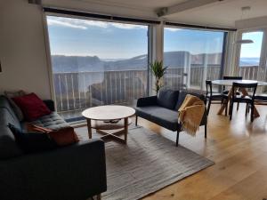 a living room with couches and a table and large windows at Lommedalen Panorama 55m2 in Bærums Verk
