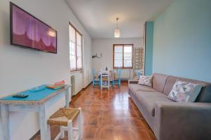 ein Wohnzimmer mit einem Sofa und einem Tisch in der Unterkunft Villa Fiorita Apartments - Happy Rentals in Sirmione