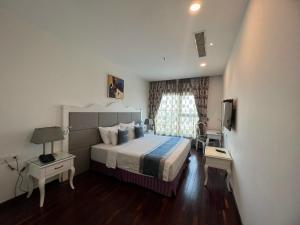 فندق ميرا في Thu Dau Mot: غرفه فندقيه سرير وتلفزيون