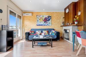 a living room with a blue couch and a fireplace at 5 minutos de la playa Torredembarra in Torredembarra