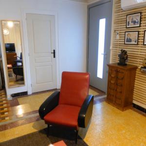 een rode stoel in een kamer met een deur bij Vintage in Perpignan in Perpignan