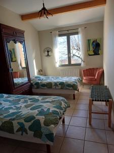 Habitación con 2 camas y una silla. en Gîte le Chêne du Py en Villié-Morgon