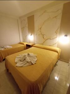 duas camas num quarto de hotel com toalhas em HOTEL INTI YACU em Termas de Rio Hondo