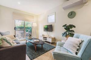 a living room with a couch and a table at Harp Haven - Contemporary in Suburban Tree lined Kew in Melbourne