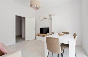 una sala da pranzo bianca con tavolo e sedie bianchi di Martina Garden a Roma