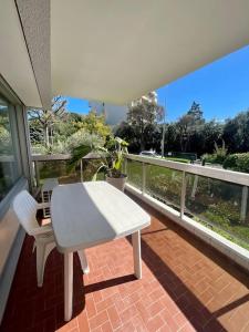a white table and chairs sitting on a balcony at Superbe 2P proche plages - Piscine in Juan-les-Pins