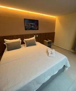 um quarto com uma grande cama branca num quarto em Premium Hotel em Delmiro Gouveia