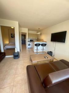 a living room with a couch and a tv and a kitchen at Superbe 2P proche plages - Piscine in Juan-les-Pins