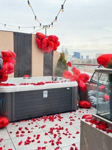 a bed with red rose petals on the ground at Luxury apartment with jacuzzi Pechersk Plaza in Kyiv