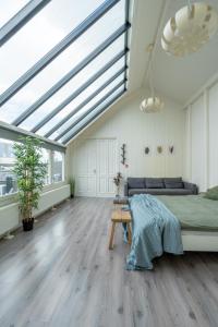 sypialnia z łóżkiem i dużym oknem dachowym w obiekcie Penthouse Amsterdam Dam Square w Amsterdamie