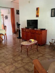 ein Wohnzimmer mit einem TV und einem Couchtisch in der Unterkunft Maison spiritaine in Saint Esprit