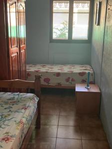 a room with two beds and a table and two windows at Maison spiritaine in Saint Esprit
