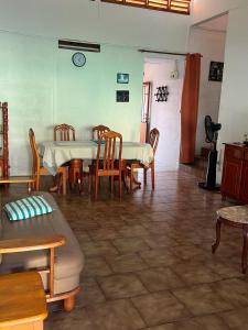 ein Esszimmer mit einem Tisch und Stühlen sowie einer Uhr an der Wand in der Unterkunft Maison spiritaine in Saint Esprit