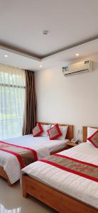 a bedroom with two beds and a window at Hotel Minh Thắng in Vung Tau