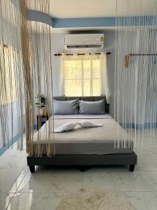 Bett mit Baldachin in einem Zimmer mit Fenster in der Unterkunft Blue sea house in Ko Phangan