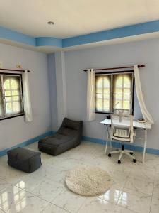 ein Wohnzimmer mit einem Sofa und einem Schreibtisch in der Unterkunft Blue sea house in Ko Phangan