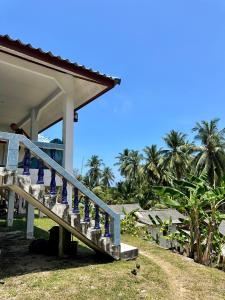 eine Treppe zu einem Haus mit Palmen im Hintergrund in der Unterkunft Blue sea house in Ko Phangan