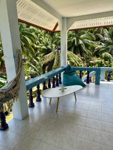 eine Veranda mit einer Bank und Palmen in der Unterkunft Blue sea house in Ko Phangan