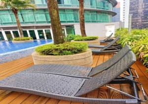 um grupo de cadeiras sentadas numa varanda com piscina em Vortex Suites KLCC By MA Tajri em Kuala Lumpur
