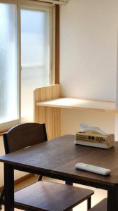 einem Tisch mit Fernbedienung, der oben drauf sitzt in der Unterkunft 松ノ木ハウス in Nobeji
